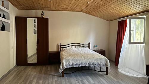 a bedroom with a bed and a mirror and a window at Cozy Qorte in Lentekhi