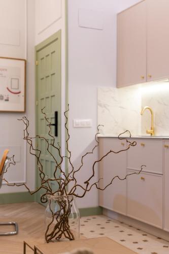 a vase filled with branches in a kitchen at Apartamentos 4Duques in Cáceres