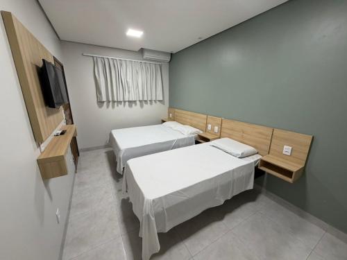 a hospital room with two beds and a tv at Hotel Colorado in Vilhena
