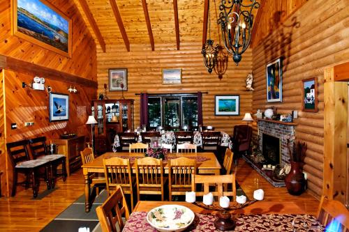 a dining room with tables and chairs and a fireplace at Tuckamore Lodge in Main Brook