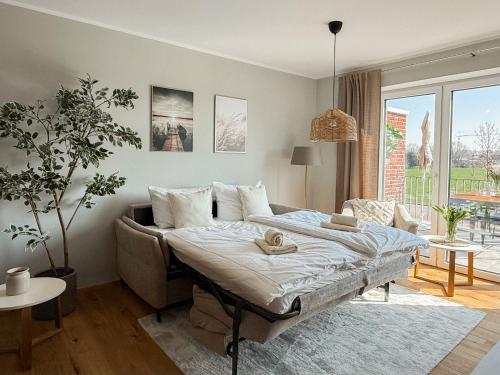 a bedroom with a bed and a couch at Ferienwohnung Sonnenufer am Dümmer See in Lembruch