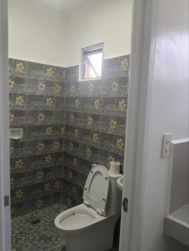 a bathroom with a toilet with the lid up at Tiza Manor Inn in Roxas City