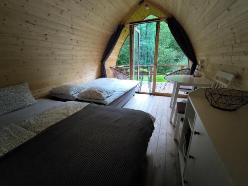 a bedroom with a bed and a table and a window at Meža namiņi Sprīdīši in Tērvete