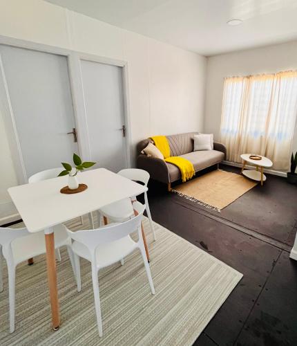 a living room with a white table and chairs and a couch at Casa Tetis in La Floresta