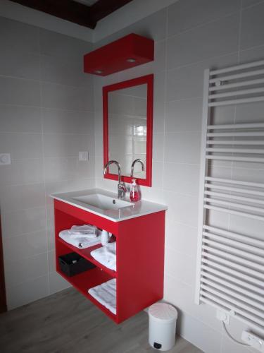a bathroom with a red sink and a red mirror at L'amandier in Thouars
