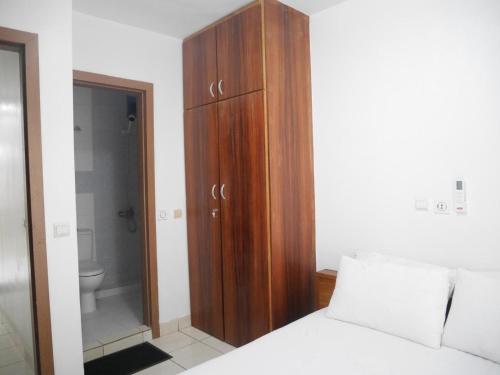 a bedroom with a wooden cabinet next to a bed at LA MAISON SEONE f4 FAMILLE in Abidjan
