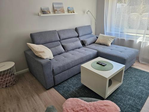 a living room with a blue couch and a table at Tohuus - Fewo bei Hamburg in Hasloh