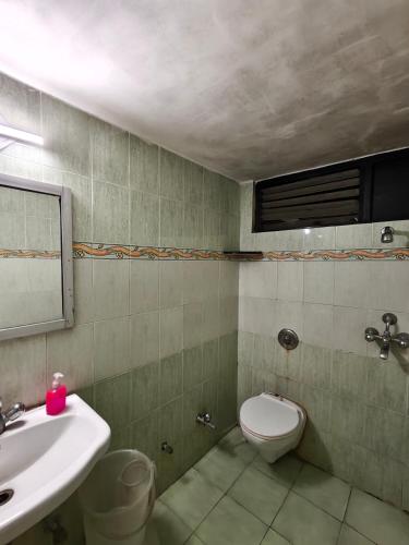 a bathroom with a sink and a toilet and a mirror at Hotel jewel in Haridwār