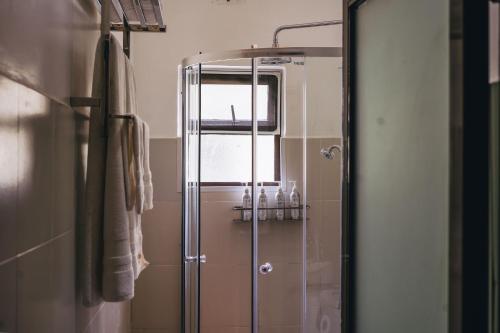 a shower with a glass door in a bathroom at Tano Bora Hotel in Sekenani