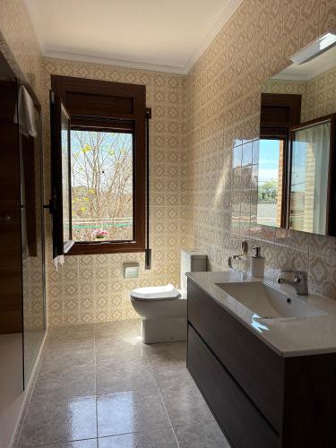 a bathroom with a sink and a toilet and a window at CASA JESUS in Abiego