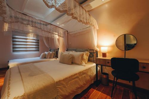 a bedroom with a bed and a desk and a mirror at Tano Bora Hotel in Sekenani