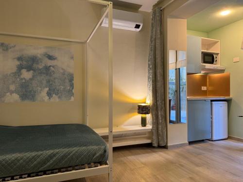 a bedroom with a canopy bed and a kitchen at Villa Dorée in Milan