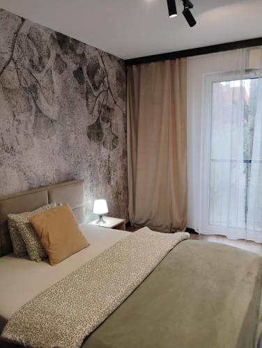 a bedroom with a large bed and a window at Parkcity Centrum in Katowice