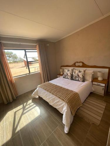 a bedroom with a bed and a large window at 4BFarming Rest camp and Camping in Naris