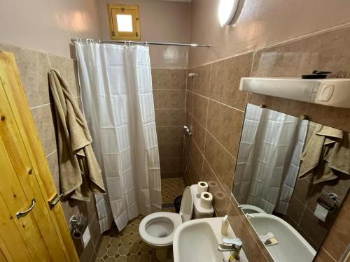 a bathroom with a toilet sink and a shower at La Baraka Auberge in Aït Benhaddou