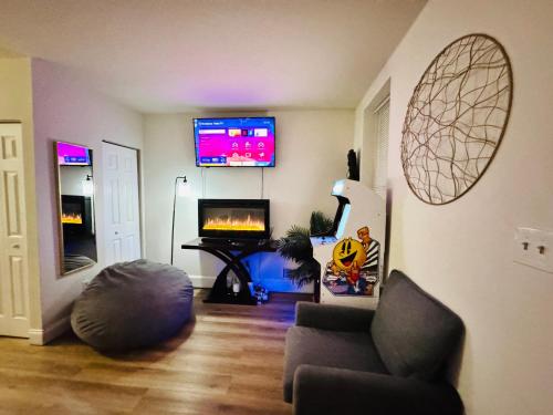 a living room with a couch and a flat screen tv at Downtown Loft - Close to Topgolf, Horseshoe Casino, UM Baltimore in Baltimore