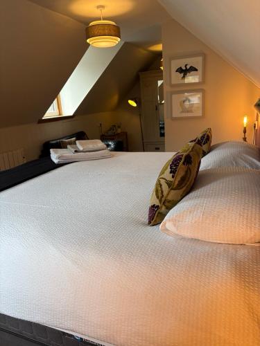 a large bed with two pillows on top of it at Highland Rooms - Room Only No Breakfast in Ullapool