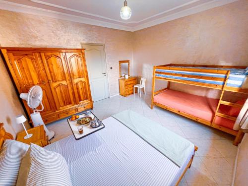 a bedroom with a bed and a bunk bed at Itrane Hostel in Tamraght Ouzdar