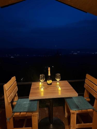a wooden table with wine glasses and a bottle of wine at Mes Pishave in Sauk