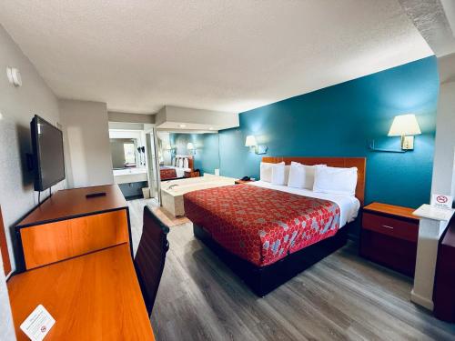 a hotel room with a bed and a television at Luxury Inn & Suites in Selma
