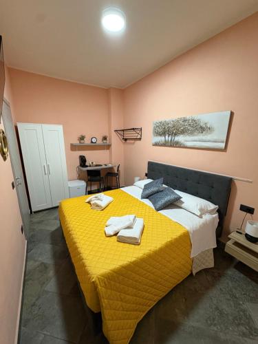 a bedroom with a yellow bed with towels on it at B&B Da Simone in Battipaglia
