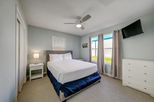 a bedroom with a white bed and a window at Wharf Cottage in Rockport