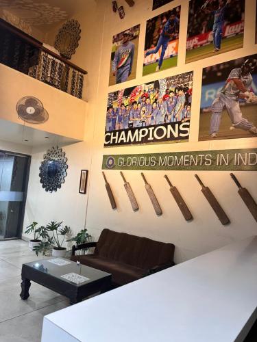 a living room with hockey posters on the wall at Hotel Gul-bahar in Satara