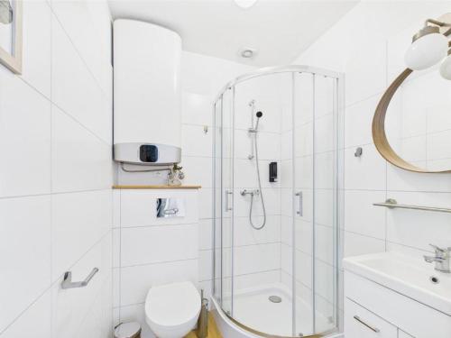 a white bathroom with a shower and a toilet at Apartament 44A Dębina I 400 m do plażyl przyjazny rowerzystom in Debina