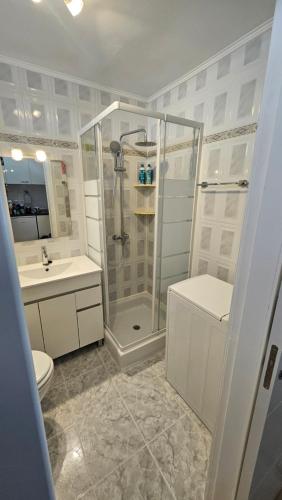 a bathroom with a shower and a toilet and a sink at Studio in perfect location in Playa de las Americas