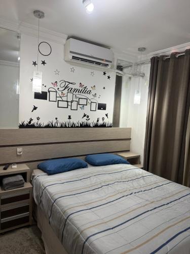 a bedroom with a bed with a sign on the wall at Apartamento próximo Aeroporto Cuiabá in Várzea Grande