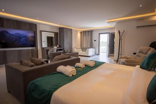 a bedroom with a large bed and a living room at Hillside hotel in Kenema