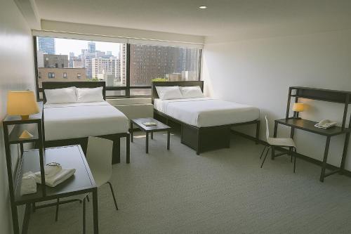 a hotel room with two beds and a window at Parkside Student Residence Downtown Toronto in Toronto