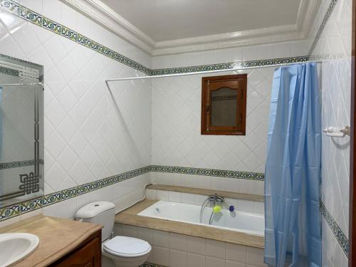 a bathroom with a tub and a toilet and a sink at La Baïa Cozy in Sukrah