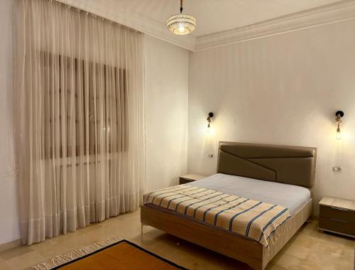 a bedroom with a bed and a large window at La Baïa Cozy in Sukrah