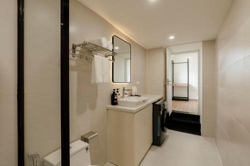 a bathroom with a sink and a toilet and a mirror at Residences A-25 in Hanoi
