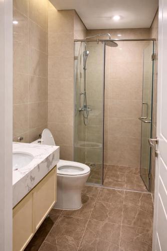 a bathroom with a toilet and a glass shower at Homemie in Binh Hai