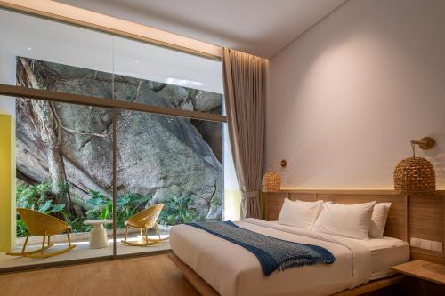 a bedroom with a bed and a large window at Ozone Cave in Thong Nai Pan Noi