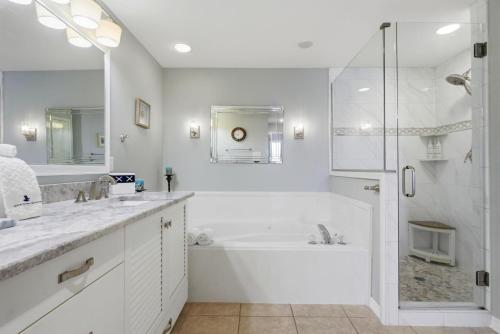 a white bathroom with a tub and a shower at Marlin Key 2D in Orange Beach