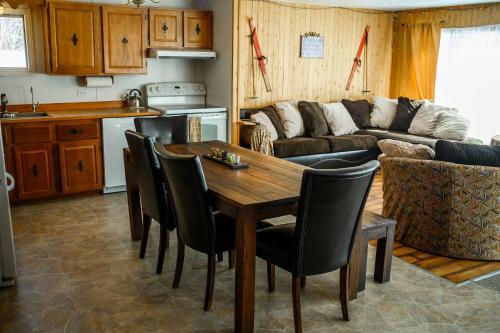a kitchen and living room with a wooden table and chairs at Upper Floor - Mont-Video in Barraute