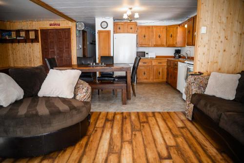 a kitchen and living room with a couch and a table at Upper Floor - Mont-Video in Barraute