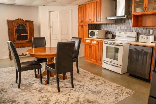 a kitchen with a wooden table and black chairs at Lower Floor - Mont-Video in Barraute