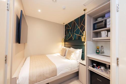 a small bedroom with a bed and shelves at NOX Kensington in London