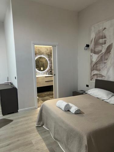 a white bedroom with a bed with a towel on it at Villa Uma con Idromassaggio e Parcheggio Privato in Sannicandro Garganico