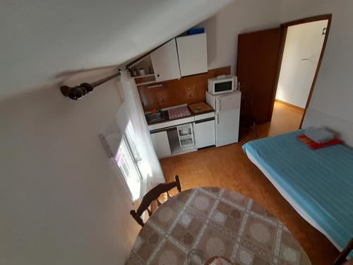 a small room with a bed and a kitchen at Apartmani Mare Palada in Marina
