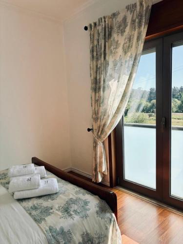 a bedroom with a bed and a large window at Casa da Pontelha VILLA INN in Ponte de Lima