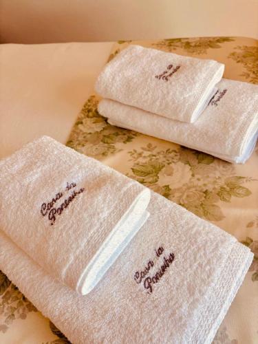 two white towels sitting on top of a table at Casa da Pontelha VILLA INN in Ponte de Lima