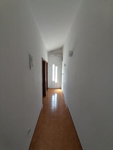 an empty hallway with white walls and a wooden floor at Apartmani Mare Palada in Marina