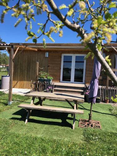 a picnic bench sitting in front of a house at Le colibri des prés in Maurens