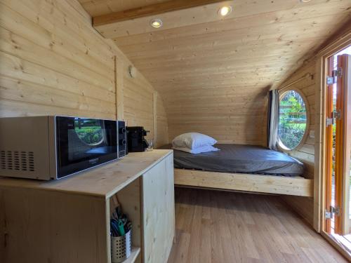 a small bedroom with a bed in a wooden house at Camping Naéco Audierne in Plouhinec