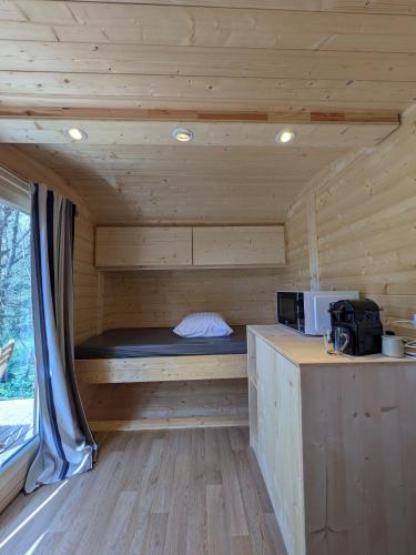 a small room with a bed in a wooden cabin at Camping Naéco Audierne in Plouhinec
